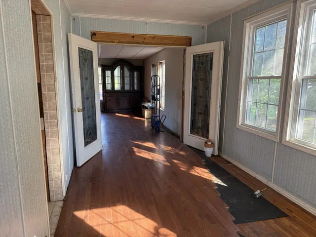 an entryway with wooden floor and windows