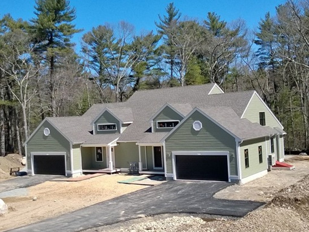 a front view of a house with yard and trees