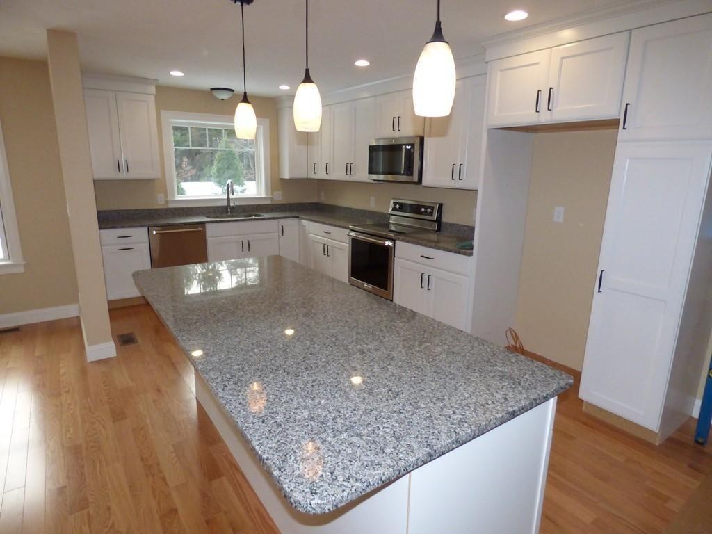 16 Kevin's Way, Unit 7 Scituate, MA 02066 - Photo 4 of 19 a kitchen with stainless steel appliances granite countertop a sink a stove and a wooden floors