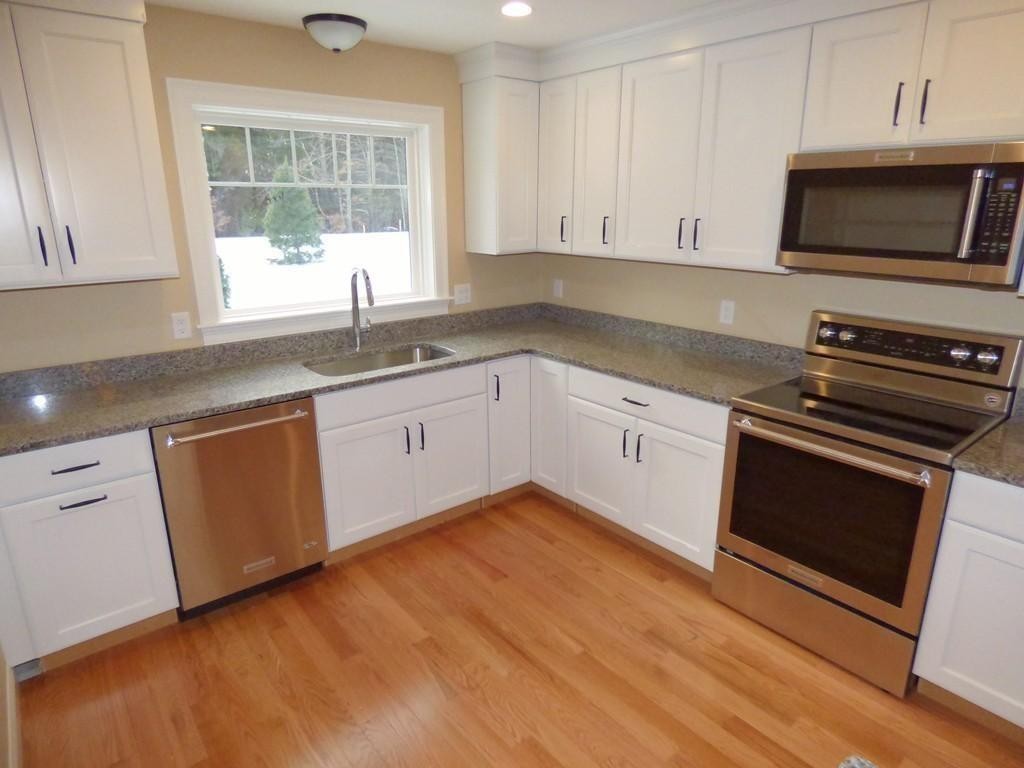 16 Kevin's Way, Unit 7 Scituate, MA 02066 - Photo 5 of 19 a kitchen with granite countertop a stove a sink and a microwave