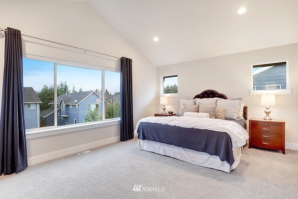 5213 Northeast 2nd Place Renton, WA 98059 - Photo 17 of 25 a spacious bedroom with a large bed and a large window