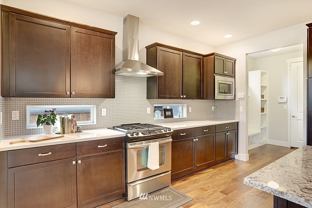 5213 Northeast 2nd Place Renton, WA 98059 - Photo 10 of 25 a kitchen with stainless steel appliances granite countertop a sink stove and refrigerator