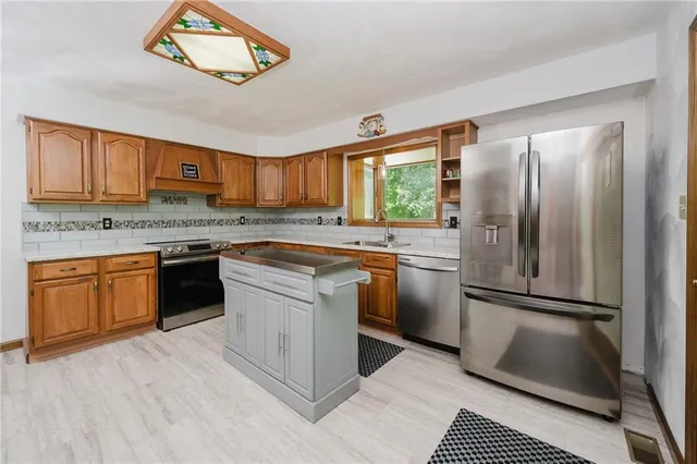 a kitchen with a refrigerator sink and a stove