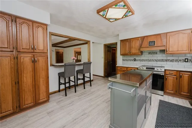 a kitchen with granite countertop wooden floors and wooden cabinets