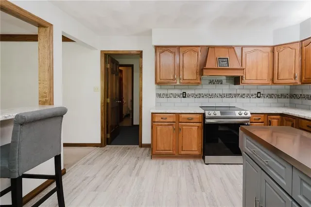 a kitchen with stainless steel appliances granite countertop wooden cabinets a stove top oven a sink and dishwasher