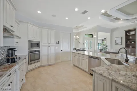a large kitchen with granite countertop a large counter top stainless steel appliances and cabinets