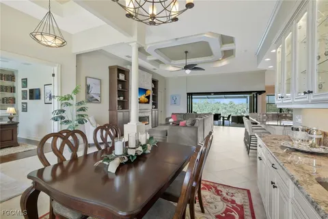 a dining room with furniture a kitchen and chandelier