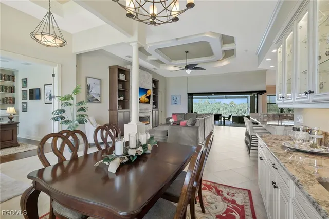 a dining room with furniture a kitchen and chandelier