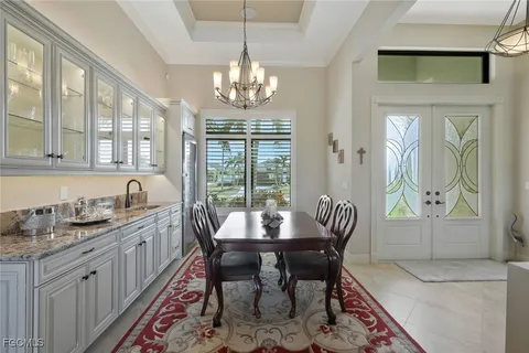a view of a dining room with furniture a chandelier and wooden floor