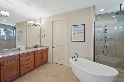 a bathroom with a tub sink double vanity granite tub and shower