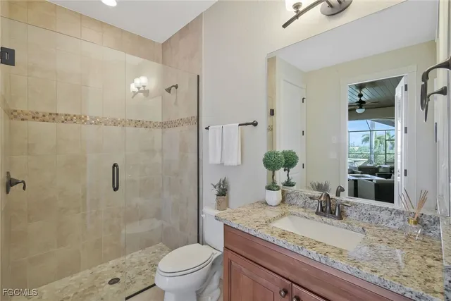 a bathroom with a granite countertop sink a toilet and shower