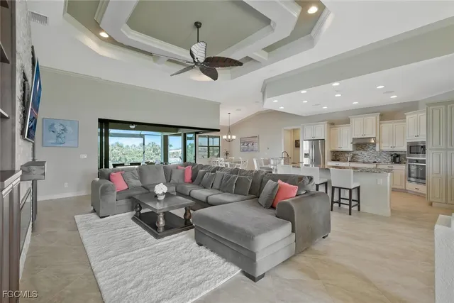 a living room with furniture kitchen view and a large window
