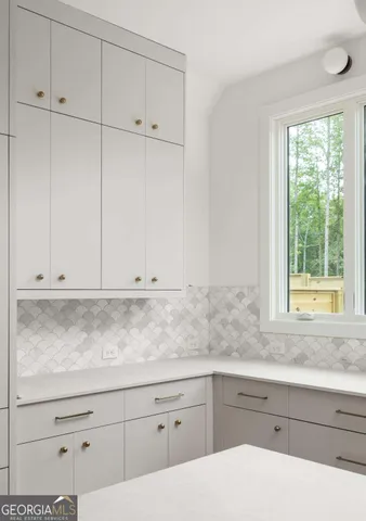 a kitchen with granite countertop white cabinets and window