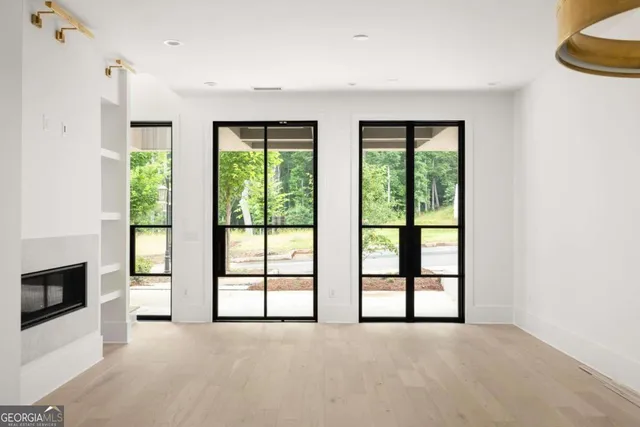 a view of an empty room with a fireplace and a window