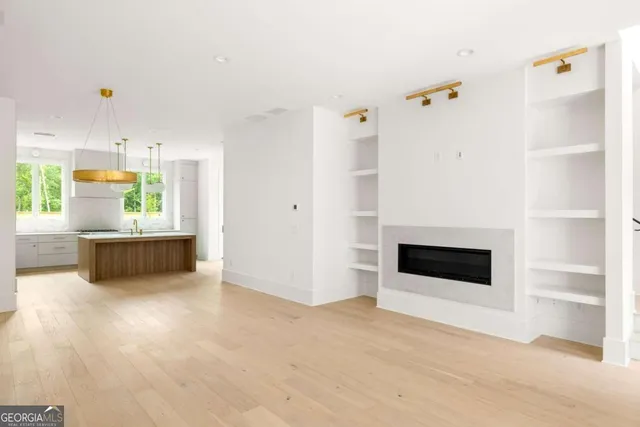 a view of an empty room with a cabinet and a kitchen view