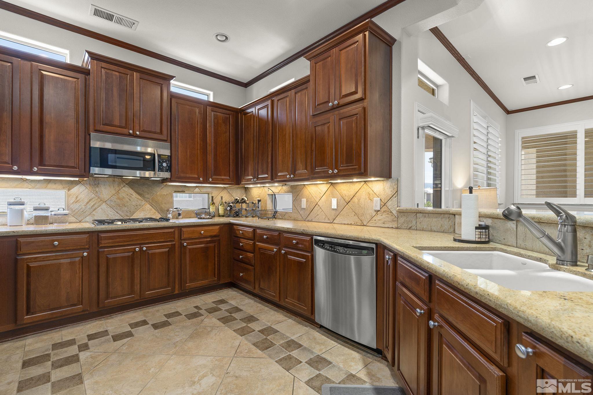 9900 Wilbur May Parkway, Unit 2404 Reno, NV 89521 - Photo 11 of 36 a kitchen with a sink stove and cabinets