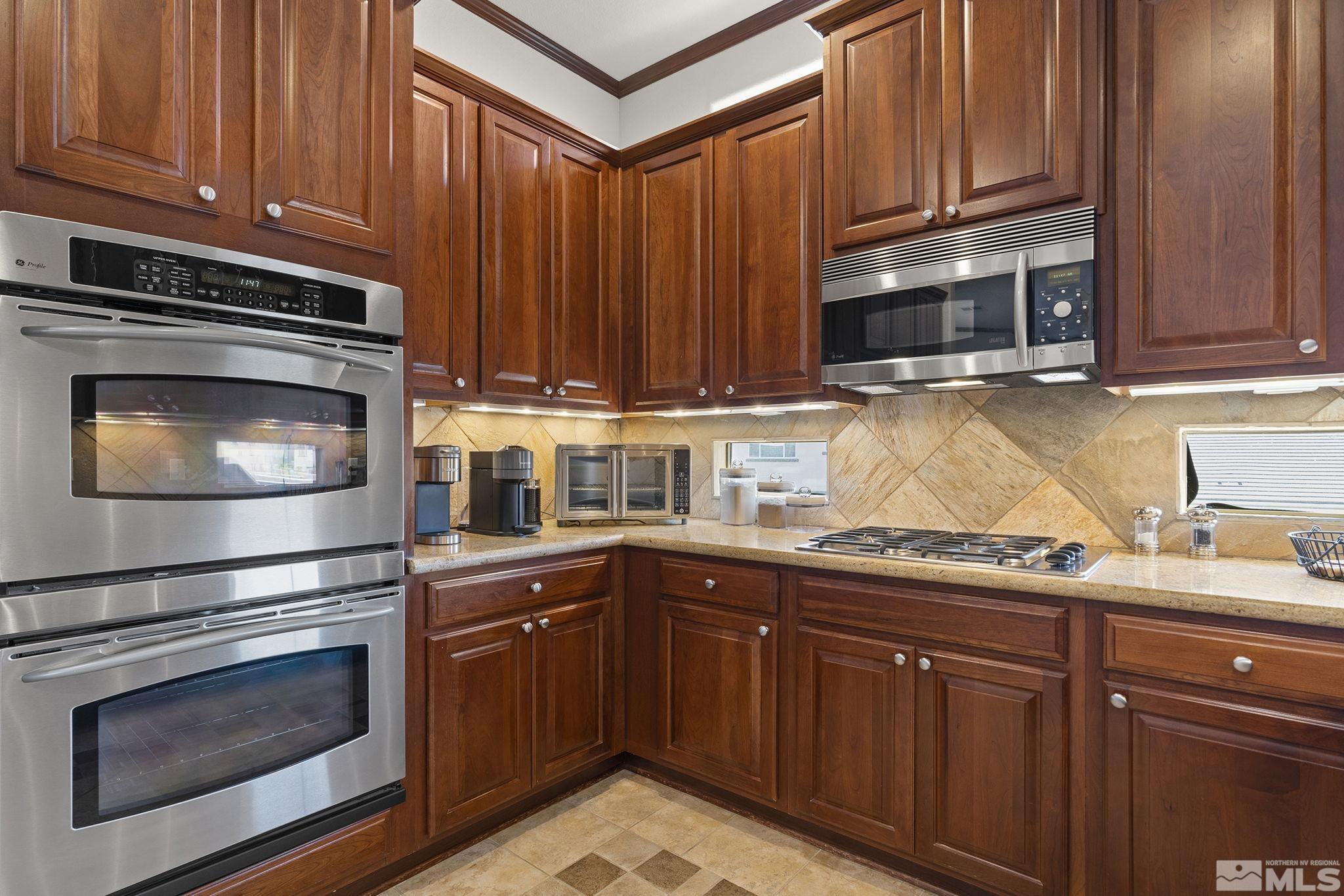 9900 Wilbur May Parkway, Unit 2404 Reno, NV 89521 - Photo 12 of 36 a kitchen with granite countertop wood cabinets stainless steel appliances and a sink