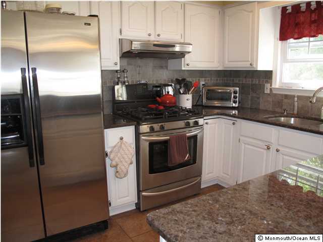 45 Sweet Gum Road Howell, NJ 07731 - Photo 11 of 25 a kitchen with stainless steel appliances granite countertop a refrigerator stove and sink