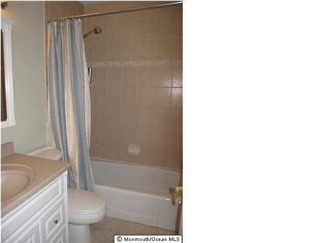 45 Sweet Gum Road Howell, NJ 07731 - Photo 21 of 25 a bathroom with a shower curtain and a toilet
