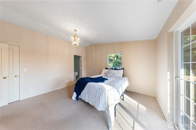 a spacious bedroom with a large bed and a chandelier
