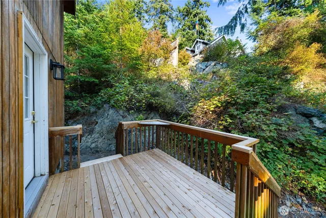 a balcony with wooden floor and yard in the back