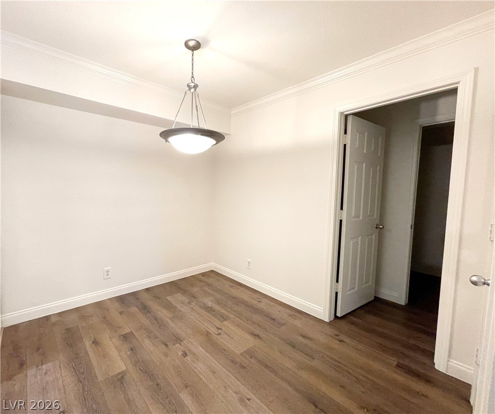 3135 South Mojave Road, Unit 221 Las Vegas, NV 89121 - Photo 8 of 19 A refined dining space features durable wood flooring and elegant crown molding, illuminated by a classic pendant light.