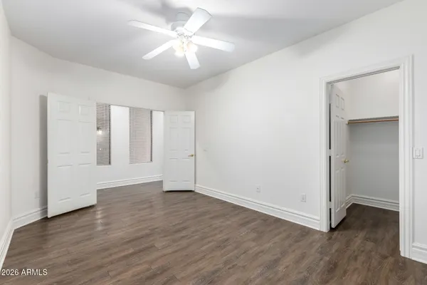 an empty room with a ceiling fan and a fan