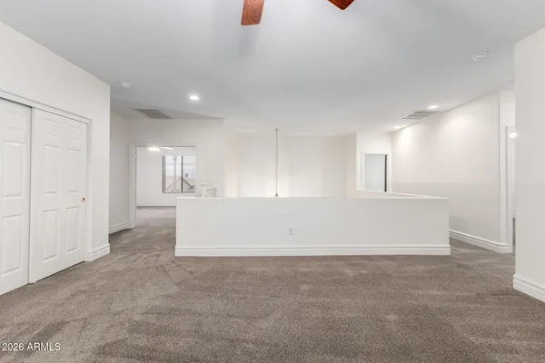 a view of an empty room with cabinet and mirrors