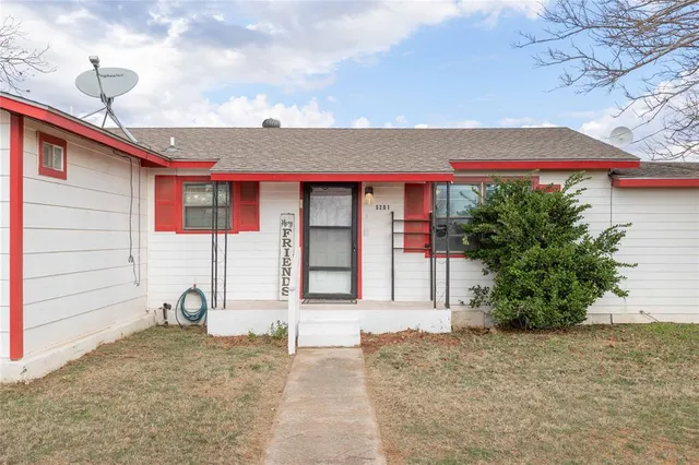 a front view of a house with basket ball court and potted plants