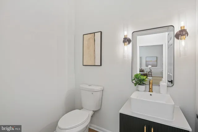 a bathroom with a toilet a sink and mirror