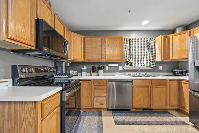 a kitchen with stainless steel appliances granite countertop a stove a sink dishwasher and a microwave oven with cabinets