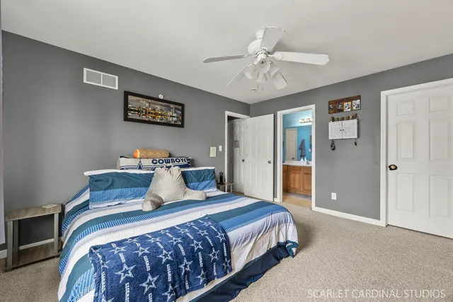 a bedroom with a large bed and a chandelier
