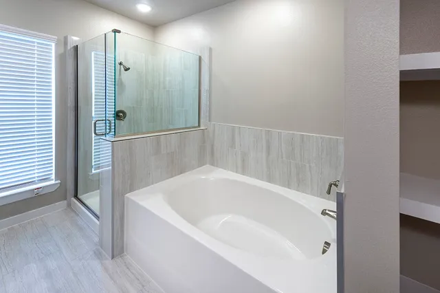 a white bath tub sitting in a bathroom and shower