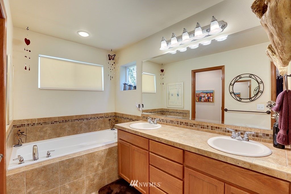 17801 20th Avenue Southeast Bothell, WA 98012 - Photo 12 of 25 a bathroom with a tub a double vanity sink and a mirror