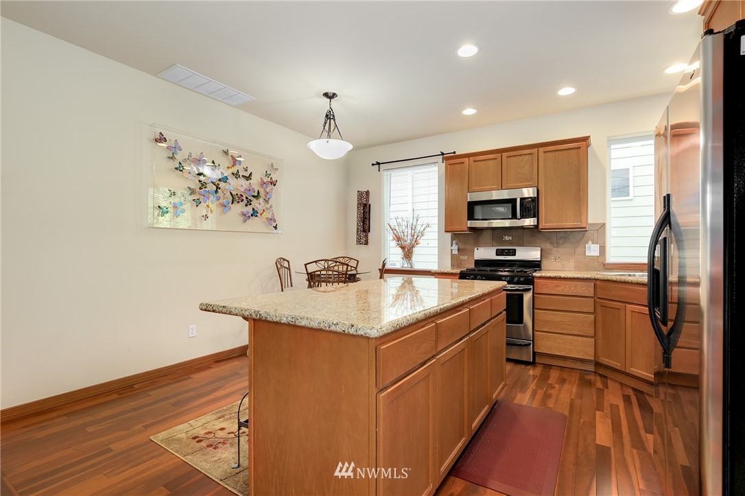 17801 20th Avenue Southeast Bothell, WA 98012 - Photo 7 of 25 a kitchen with kitchen island granite countertop a sink appliances cabinets and a counter top space