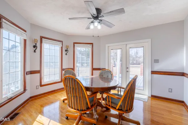 a dining room with furniture a chandelier and wooden floor