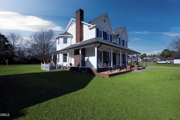 a dining room with furniture a chandelier and wooden floor