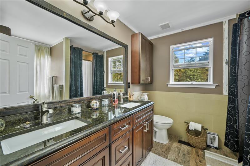 5303 Meadows Lake Crossing Southwest Powder Springs, GA 30127 - Photo 12 of 53 a bathroom with a granite countertop double vanity sink a mirror and a window