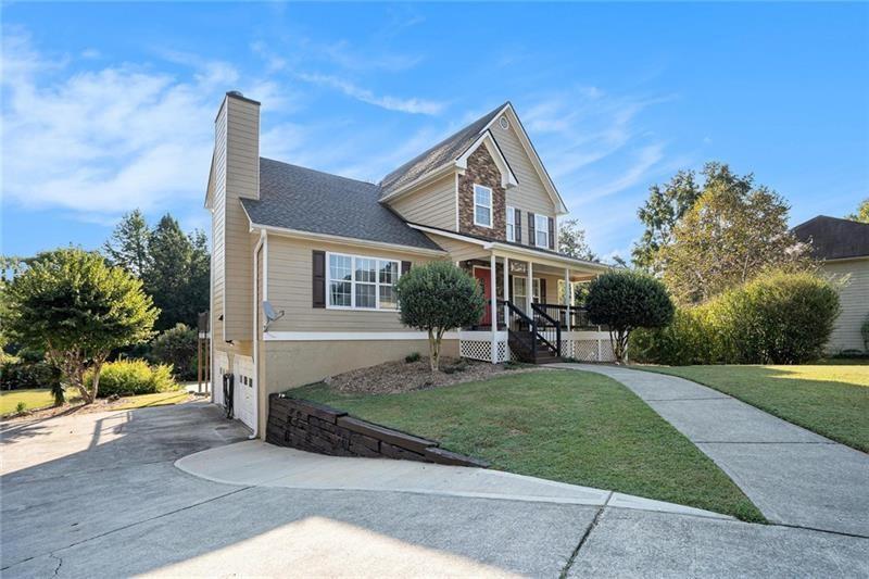 5303 Meadows Lake Crossing Southwest Powder Springs, GA 30127 - Photo 2 of 53 a front view of a house with a yard and trees
