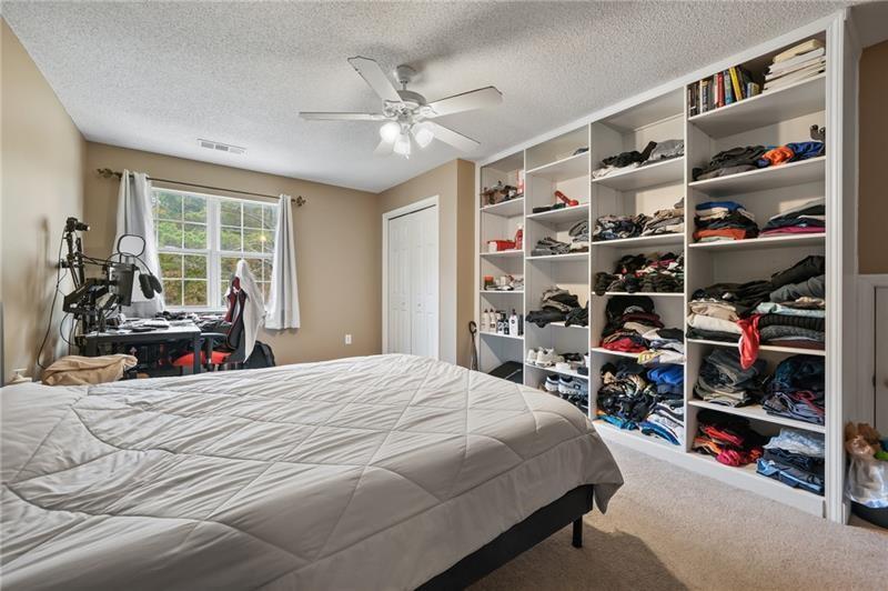 5303 Meadows Lake Crossing Southwest Powder Springs, GA 30127 - Photo 23 of 53 a bedroom with a bed a book shelf and a book shelf