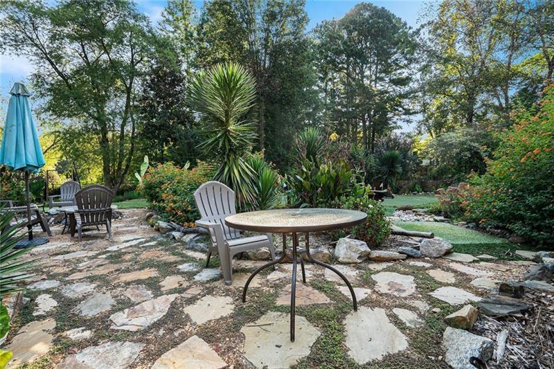5303 Meadows Lake Crossing Southwest Powder Springs, GA 30127 - Photo 38 of 53 a view of a backyard with table and chairs potted plants and large tree