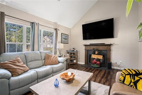 a living room with furniture a flat screen tv and a fireplace