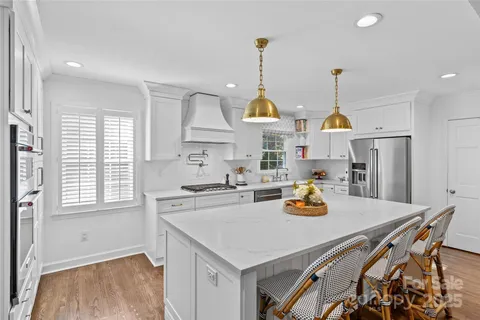 a kitchen with a sink a stove and chairs