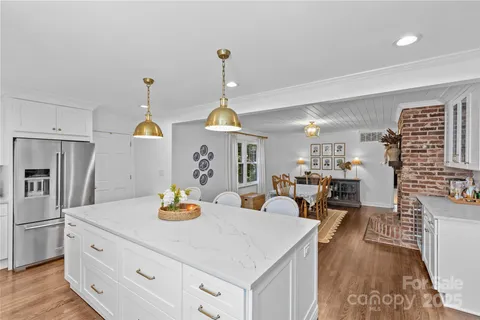 a kitchen with stainless steel appliances granite countertop a sink a stove and refrigerator