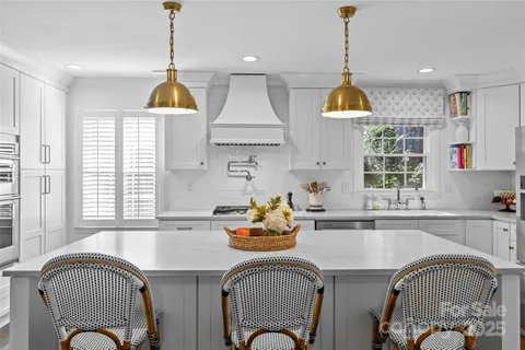 a kitchen with a refrigerator a sink a stove and a window