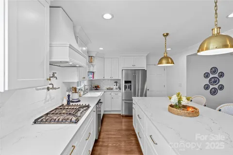 a kitchen with stainless steel appliances a stove a sink a refrigerator and cabinets