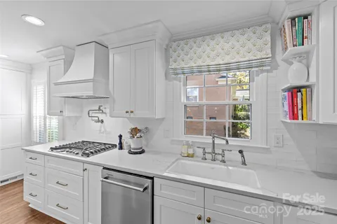 a kitchen with stainless steel appliances cabinets a large window and a sink
