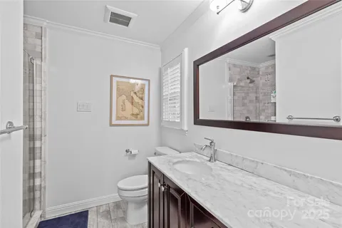 a bathroom with a granite countertop sink a toilet and a mirror
