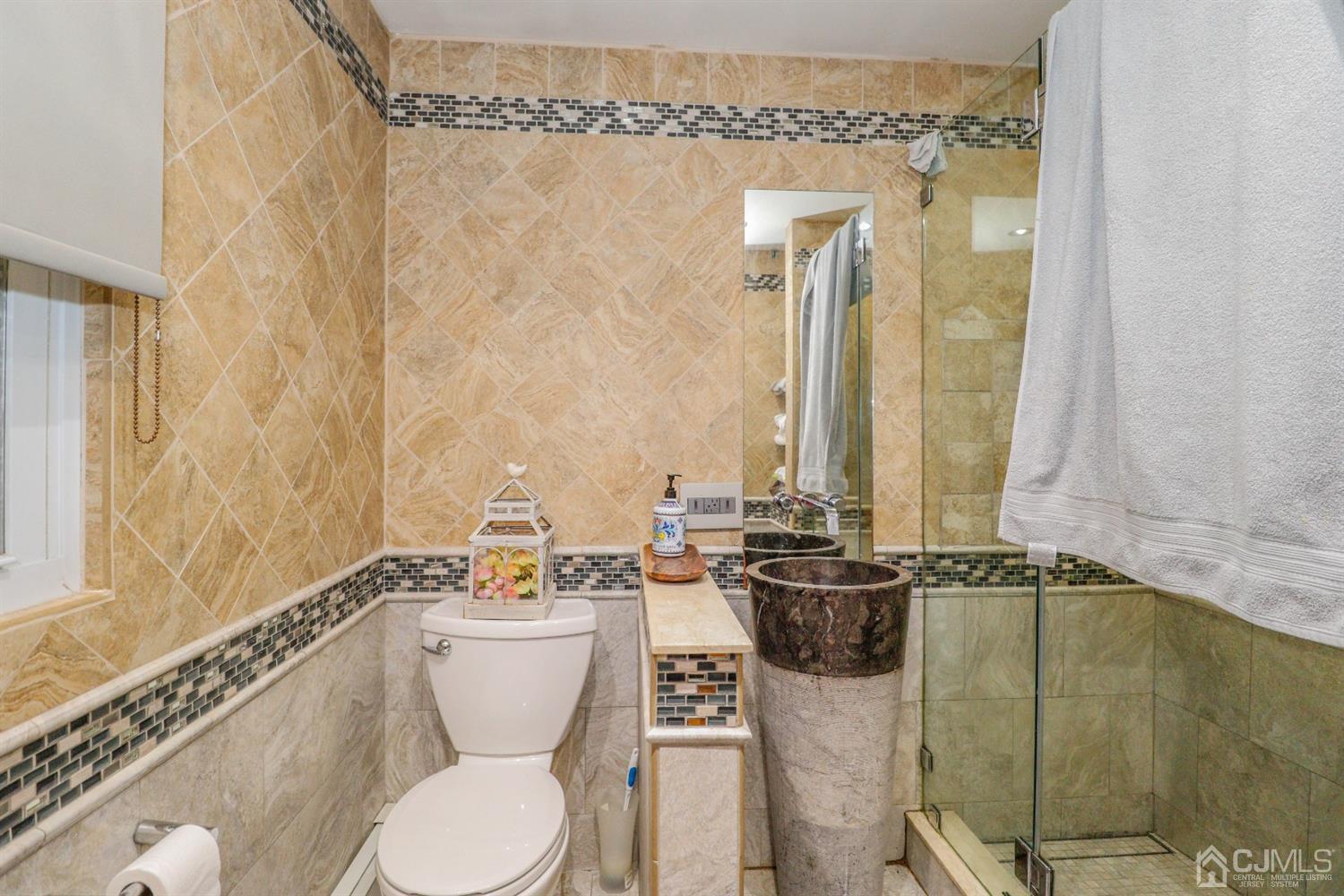 23 Matson Road Edison, NJ 08817 - Photo 19 of 28 a bathroom with a toilet a sink and mirror