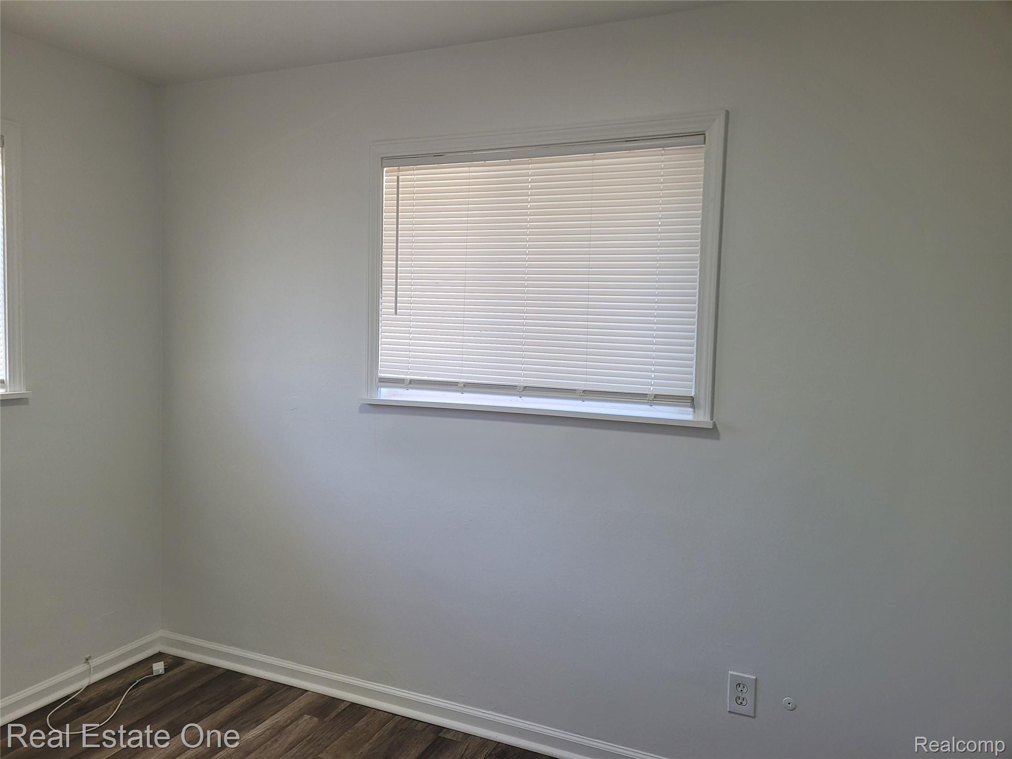 77 West Rutgers Avenue Pontiac, MI 48340 - Photo 6 of 12 Empty room featuring baseboards and dark wood-style flooring